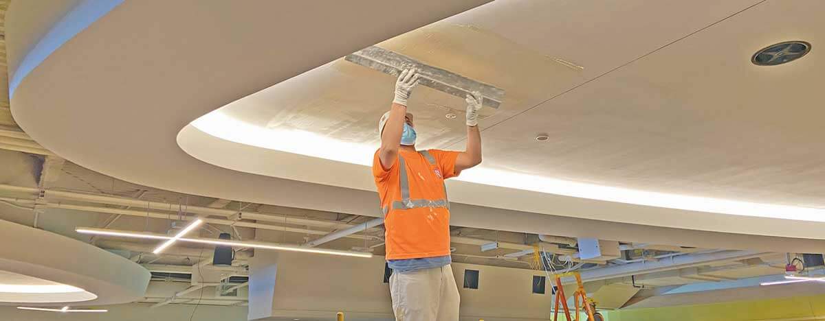 wide-angle-drywall-craftsman-finishing-ceiling-with-large-tool